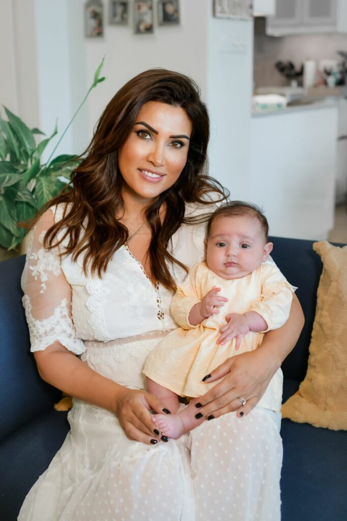 Dr. Rafif Tayara as a new working mother holding her baby, before becoming a pediatric dentist in Dubai