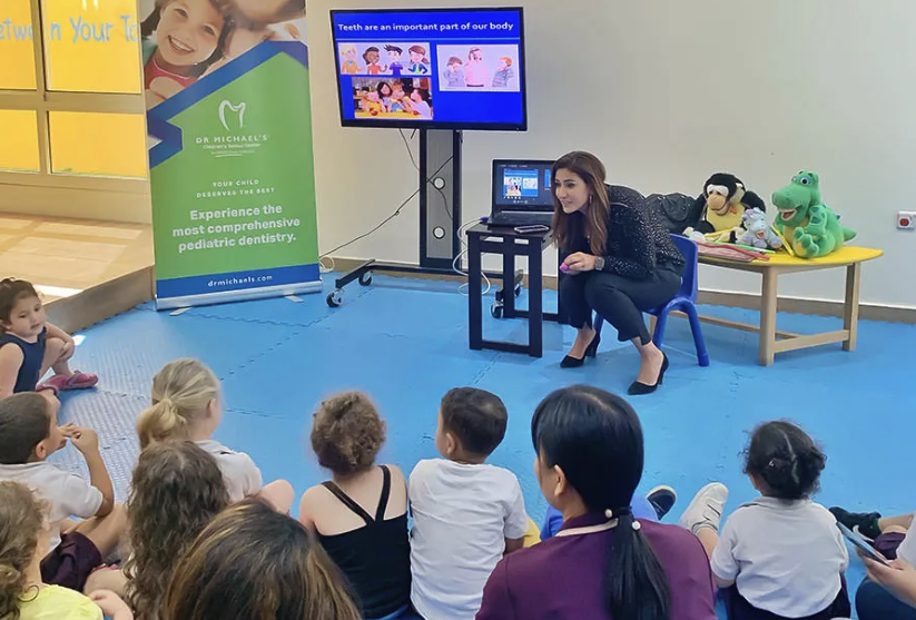 Dr. Rafif Tayara reading her children’s book about oral healthcare to a group of children